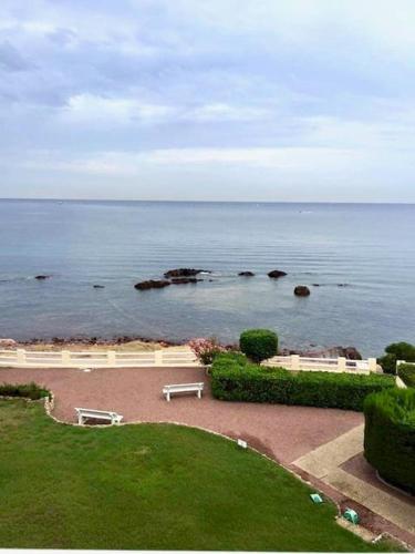 un parc avec vue sur l'océan avec des bancs dans l'établissement Saint-Raphaël Le Salus, à Saint-Raphaël