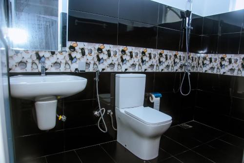 a bathroom with a white toilet and a sink at Royal Palace Mirissa in Mirissa