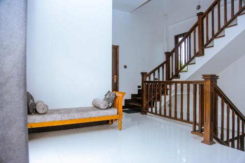 a living room with a bench and a staircase at Royal Palace Mirissa in Mirissa