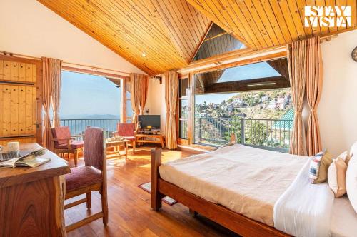 a bedroom with a bed and a large window at StayVista at The Rustic Retreat - 4BHK Valley View villa with Lawn, Bonfire in Kasauli