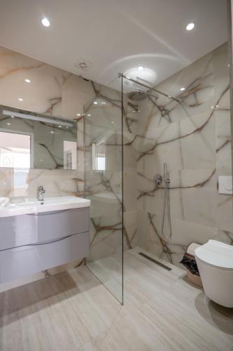 un bagno con lavandino e doccia di Geart Apartments a Sarandë