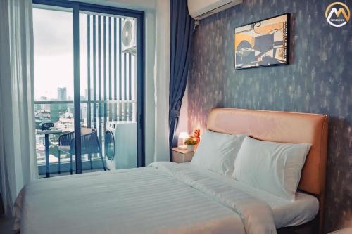 a bedroom with a bed and a large window at Hotel Serviced Condo Unique Infinity Pool with Mekong River View in Phnom Penh