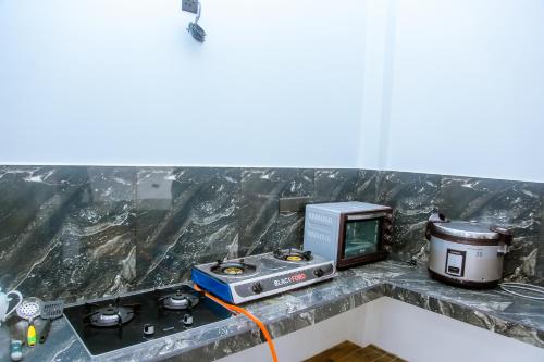 a kitchen with a stove and a microwave at Royal Palace Mirissa in Mirissa
