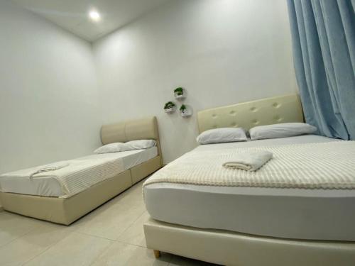 two twin beds in a room with at Alyn Home Klebang Netflix Coway Wifi in Melaka
