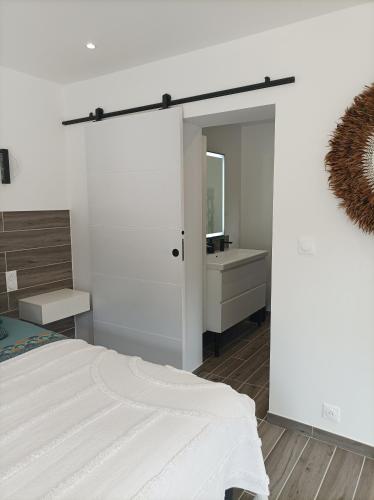 une chambre blanche avec un lit et un miroir dans l'établissement L' Har & Lam, à Leuilly-sous-Coucy