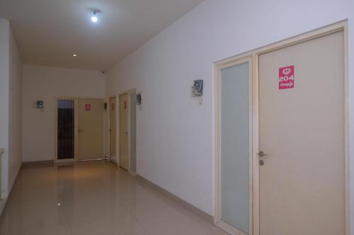 an empty hallway with doors in a building at RedDoorz Syariah Near Simpang Lima Semarang in Jomblang