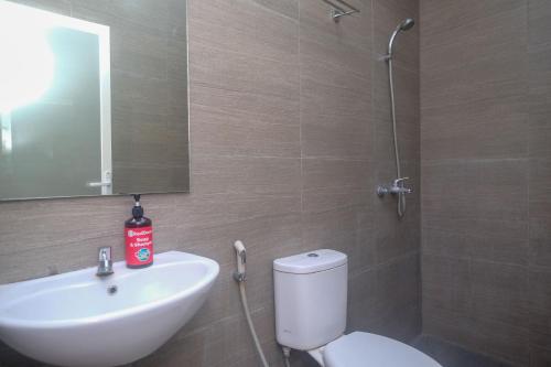 a bathroom with a sink and a toilet and a mirror at RedDoorz Syariah Near Simpang Lima Semarang in Jomblang