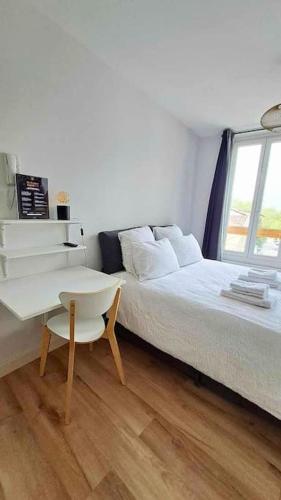 une chambre avec un lit, une table et un bureau dans l'établissement Vivent 5 - Studio Agen, à Agen
