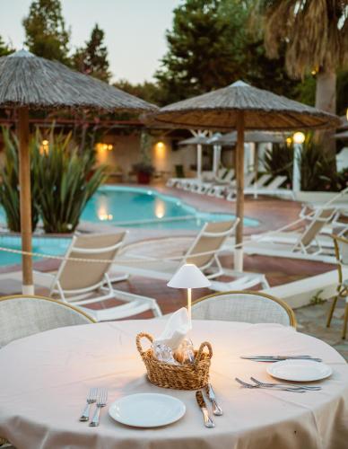 a table with a basket of food on it next to a pool at Almira Hotel in Troulos