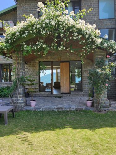 a building with a bunch of flowers on it at Woodsmoke Retreat in Shimla