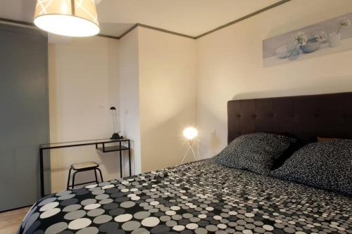 ein Schlafzimmer mit einem schwarz-weißen Bett und einer Lampe in der Unterkunft Résidence Armagnac - City Center in Carcassonne