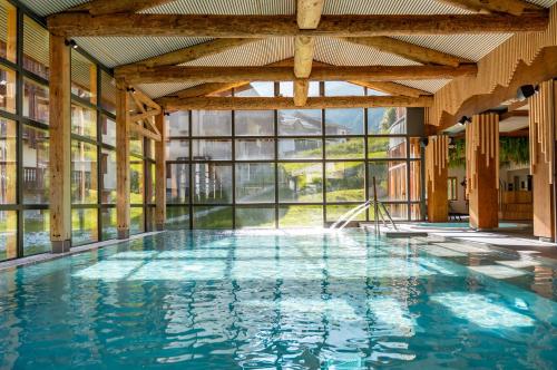 une piscine intérieure avec une grande fenêtre dans l'établissement Résidence Les Balcons de Val Cenis Village, à Lanslevillard