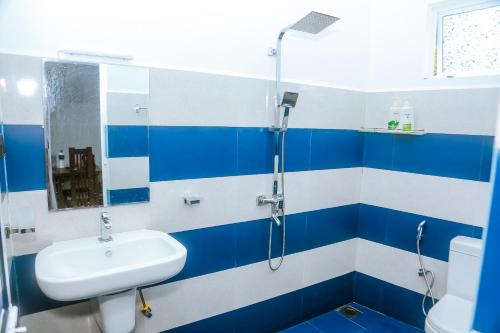 a blue and white bathroom with a sink and shower at Royal Palace Mirissa in Mirissa