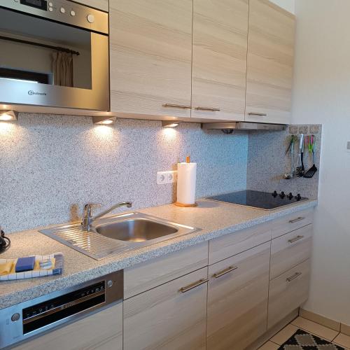 a kitchen with a sink and a microwave at Haus Obermaiselstein in Obermaiselstein