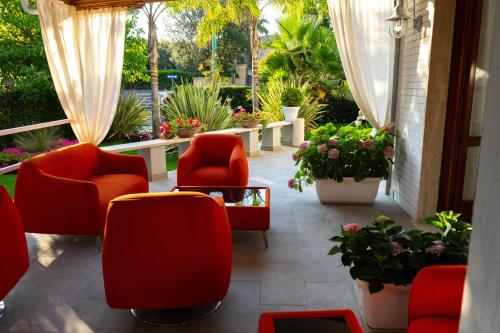 a patio with chairs and tables and plants at Park Hotel Giusy in Lido di Camaiore