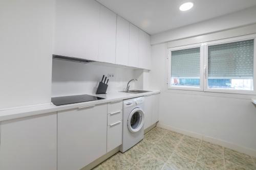a white kitchen with a sink and a washing machine at VALERIA-DREAMS Maestro Luna 3º in Zaragoza