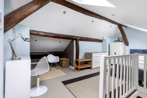a attic room with a staircase and a white chair at Paris - Cosy Duplex près des Champs Elysées in Neuilly-sur-Seine