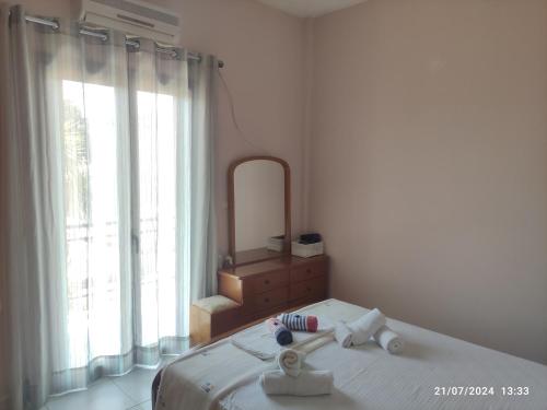 a white bedroom with a bed and a mirror at Nina's Cozy Home in Chrani