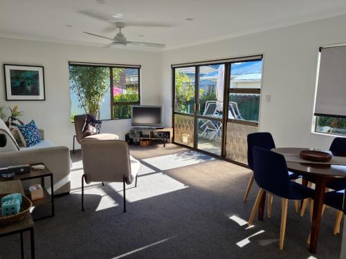 a living room with a couch and a table and chairs at Cambria Hideaway in Nelson