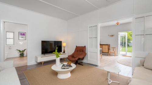 a living room with a couch and a tv at Brunswick Beach Shack in Brunswick Heads