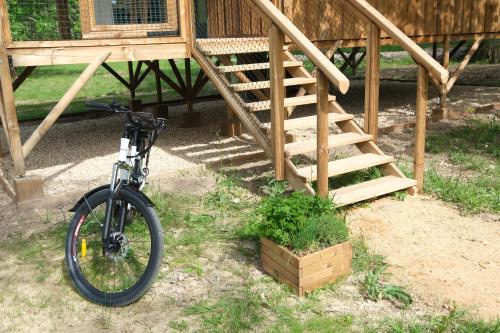 a bike parked in front of a building with a staircase at Les Cabanes de Lara in Ménesplet