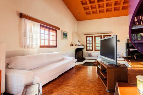 a living room with a white couch and a flat screen tv at Unique Villa nearby Kalamata in Ánthia