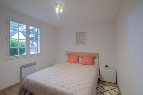 - une chambre avec un lit et 2 oreillers roses dans l'établissement Villa Bihen - Maison à 50m de la plage, à Pénestin