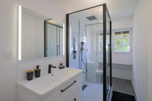 une salle de bain blanche avec un lavabo et une douche dans l'établissement Villa Bihen - Maison à 50m de la plage, à Pénestin