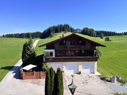a large house with a garage in a field at Ferienhaus Praschberg in Niederndorferberg