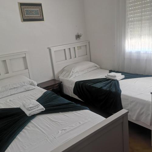 two beds in a room with white walls at Finca Bella Terra in Camarles