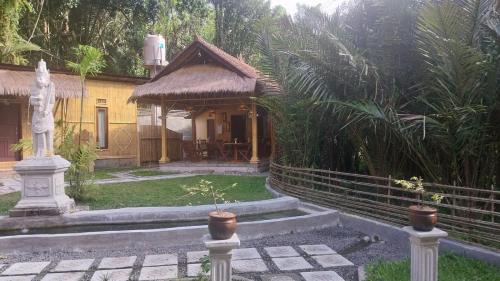 a house with a garden with a statue in front of it at Pondok Sapta Sallaca in Selat