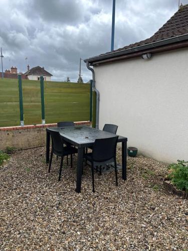 une table et des chaises noires à côté d'un bâtiment dans l'établissement Hyper centre, calme, extérieur, à Romorantin-Lanthenay