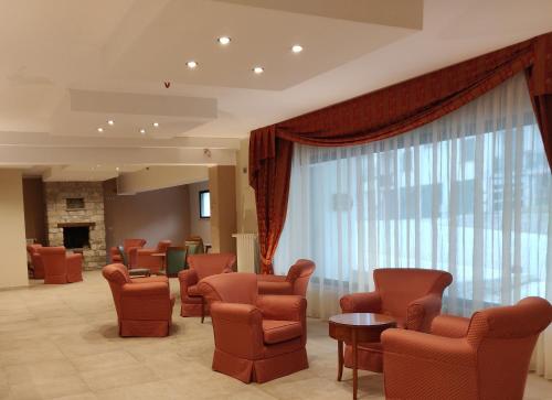 a waiting room with chairs and tables and a window at Albergo Conte Max in Capracotta