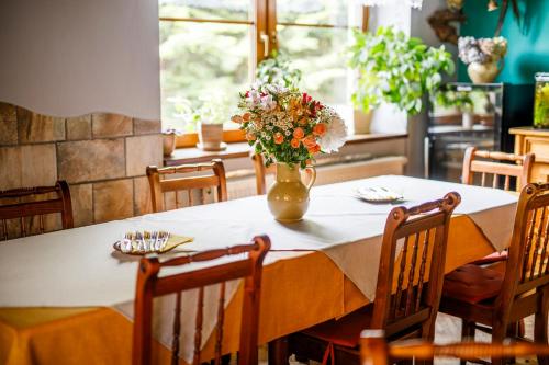 a table with a vase of flowers on it at Hotel Kačenka in Králíky