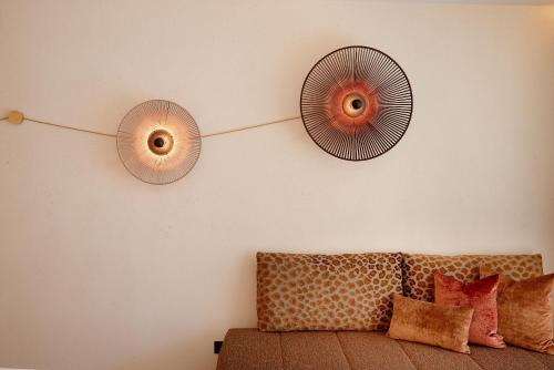 two fans hanging on a wall next to a couch at Hotel Neue Post in Mayrhofen