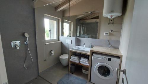 a bathroom with a washing machine and a sink at VILA ŠKARLANIJA, Umag in Umag