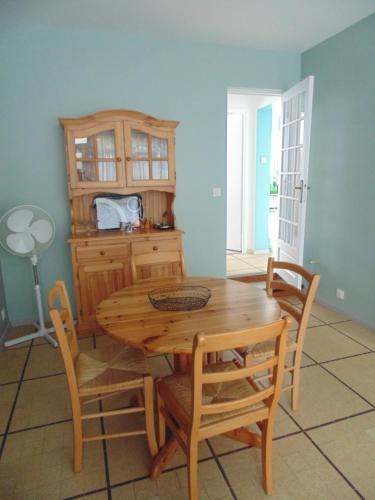 a dining room with a wooden table and chairs at Appartement entièrement rénové avec Wifi tout à pied in Royan
