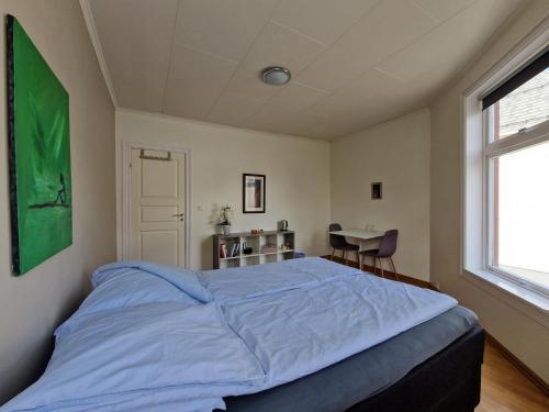 a bedroom with a bed and a table and a window at Cozy Retreat in the Heart of Ålesund in Ålesund
