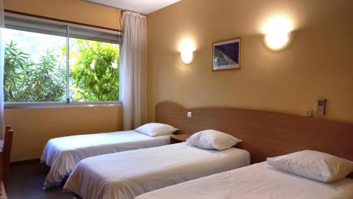 Postel nebo postele na pokoji v ubytování Hôtel Sous l'Olivier