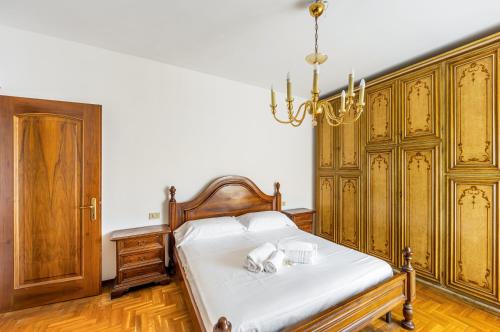 a bedroom with a bed with white sheets and a chandelier at Cozy Apartment near Venice with Balcony! in Campalto