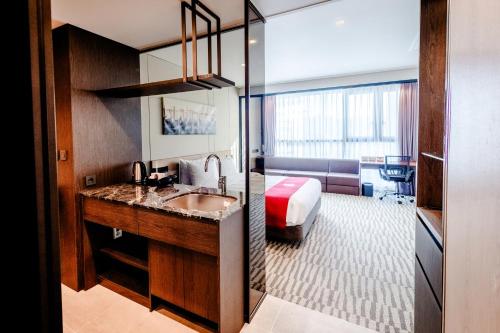 a hotel room with a sink and a bedroom at Best Western Plus Jeonju in Jeonju