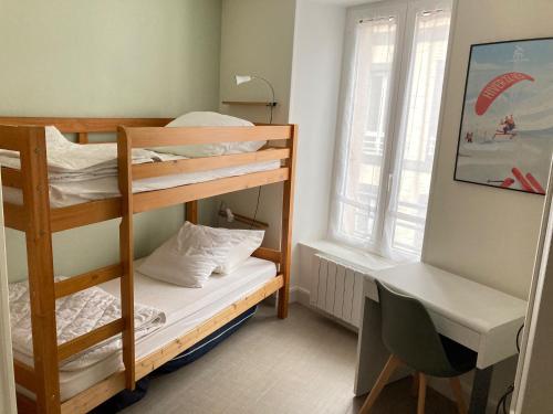 Zimmer mit Etagenbett, 2 Etagenbetten und einem Schreibtisch in der Unterkunft Les Chamois du Sancy in Le Mont-Dore