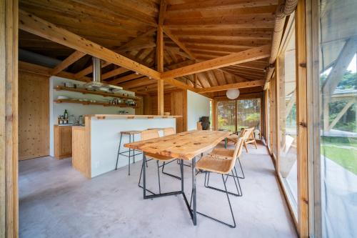 a dining room with a wooden table and chairs at SHINMINKA Villa TAMASHIRO in Nakijin