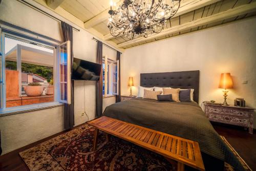 a bedroom with a large bed and a chandelier at The Stone House in Zaton