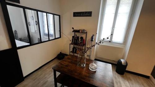 Cette chambre dispose d'une table en bois avec un vase de fleurs. dans l'établissement Très joli T2 dans la vieille ville, à Angoulême