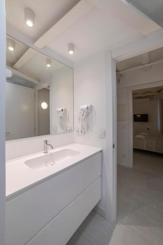 a white bathroom with a sink and a mirror at VALERIA-DREAMS Loscos 3º in Zaragoza