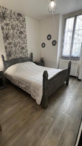 une chambre avec un grand lit dans une pièce dans l'établissement Très joli T2 dans la vieille ville, à Angoulême