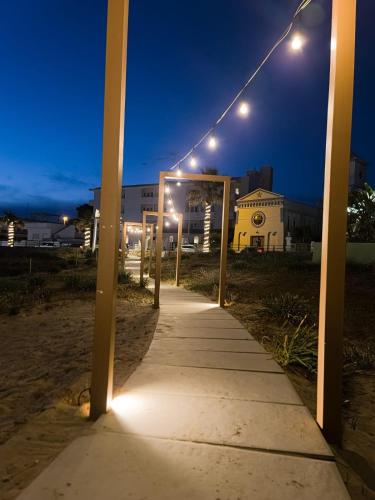 a sidewalk with lights on it at night at Montedarena Hotel in Pulsano