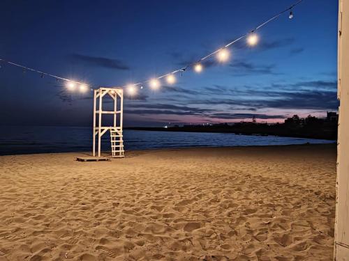 a beach with a life ladder and lights on it at Montedarena Hotel in Pulsano