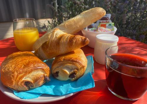 - un plat avec des croissants et un verre de jus d'orange dans l'établissement La Promenade des 2 Pins - Bohème, à Poisat